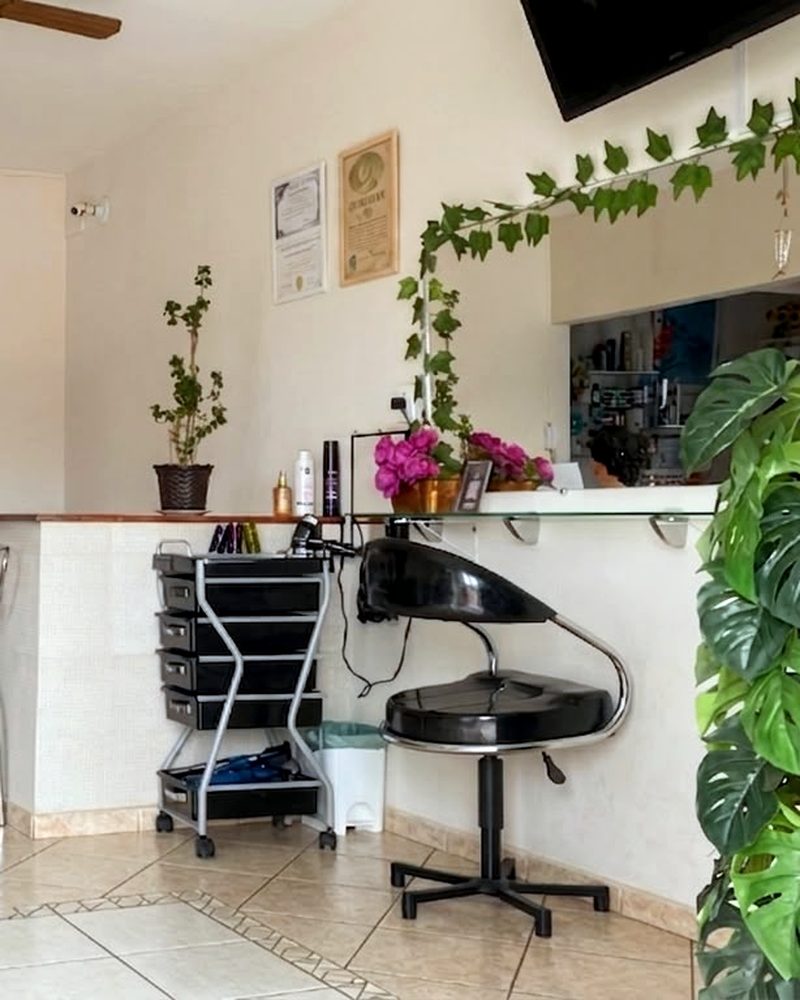 Espaço de atendimento do salão Marli Cabeleireira, com carrinho de produtos, cadeira e bancada